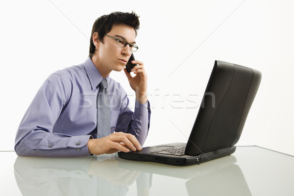 Biznesmen laptop komórka asian posiedzenia biurko Zdjęcia stock © iofoto