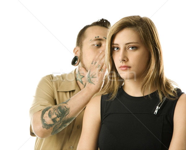 Tattooed man whispering to girl. Stock photo © iofoto