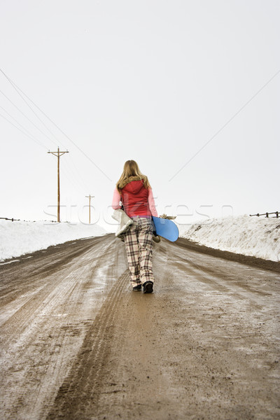 Stock photo: Woman carrying snowboard.