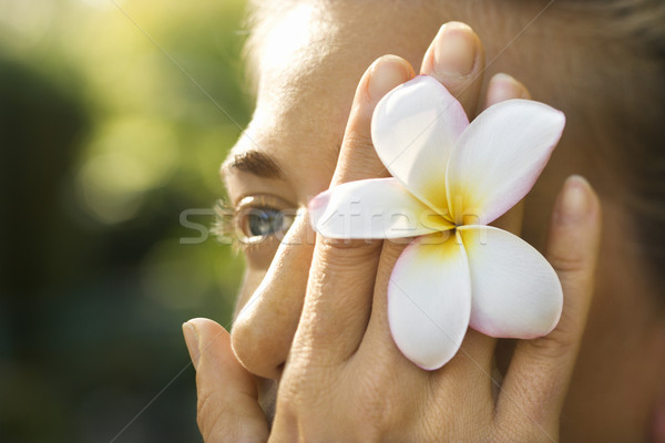 Plumeria flower over woman's eye. Stock photo © iofoto