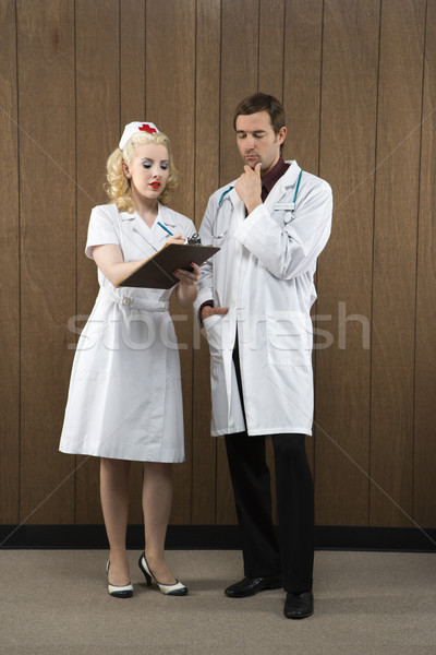 Retro asistentă medic caucazian femeie medic de sex masculin Imagine de stoc © iofoto