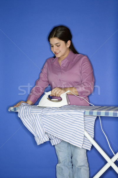 Teenage girl ironing shirt.  Stock photo © iofoto