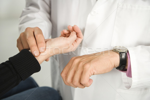 Stock photo: Doctor taking patient's pulse.