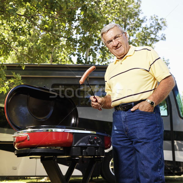 Senior man grilling by RV. Stock photo © iofoto