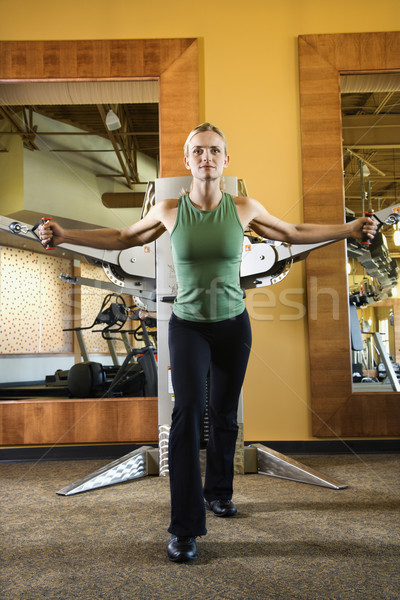 Woman using exercise equipment. Stock photo © iofoto