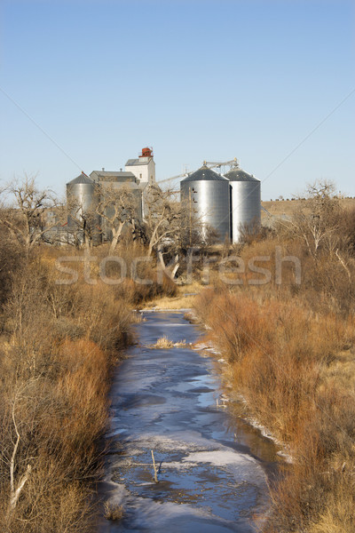 Storage silos by creek. Stock photo © iofoto