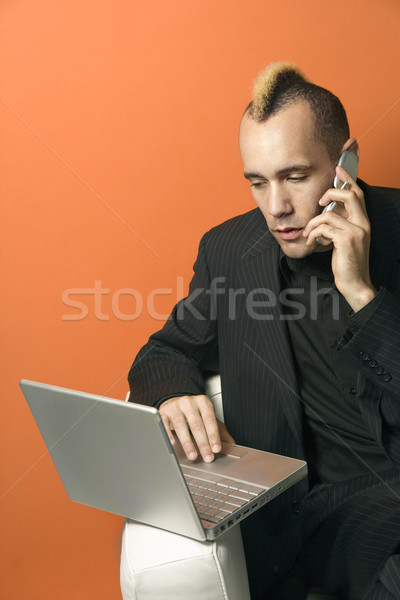 Stock photo: Man with laptop and cellphone.