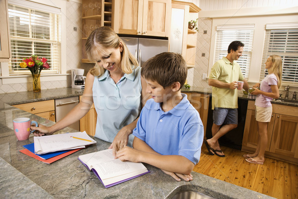Family in kitchen doing homework and chatting. Stock photo © iofoto