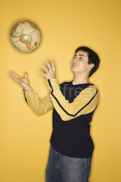 Teen boy tossing globe. Stock photo © iofoto