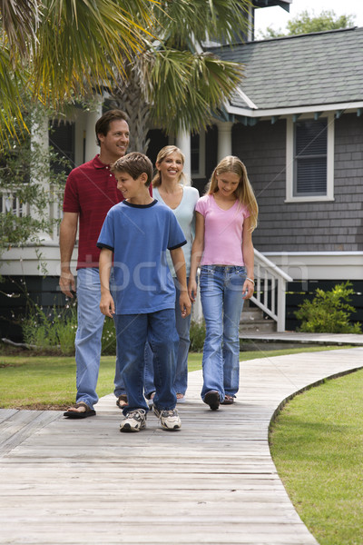 Familia cuatro caminando caucásico abajo suburbano Foto stock © iofoto