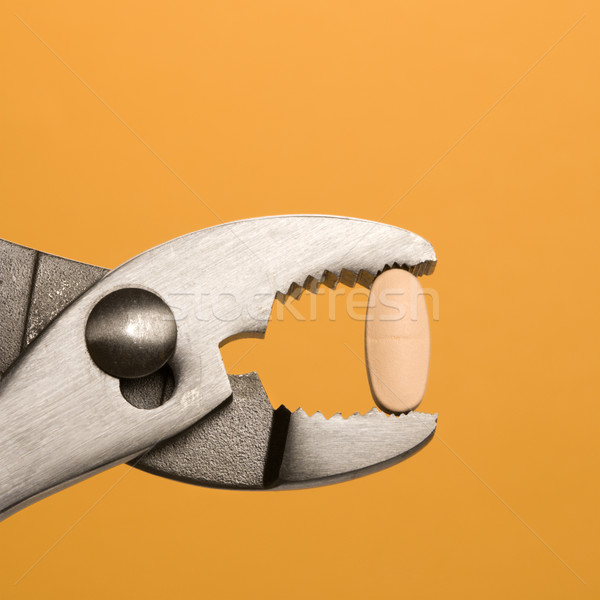 Pill Gripped With Pliers. Isolated Stock photo © iofoto