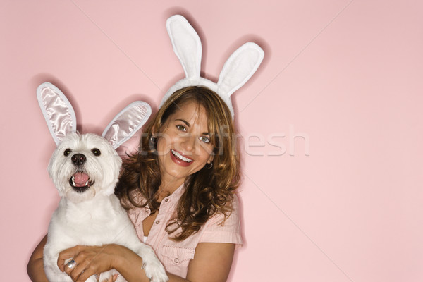 Woman and white dog wearing rabbit ears. Stock photo © iofoto