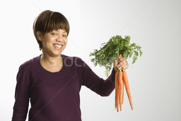 Woman holding carrots. Stock photo © iofoto
