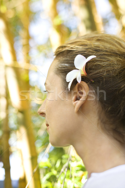 Woman wearing plumeria flower. Stock photo © iofoto