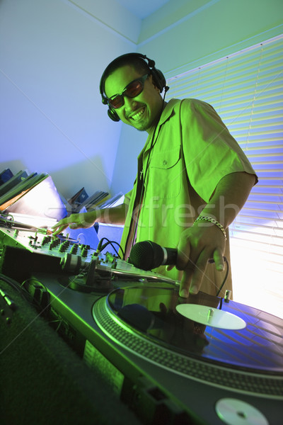 Stock photo: Male DJ with hand on record.