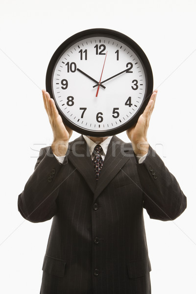 Businessman holding clock. Stock photo © iofoto