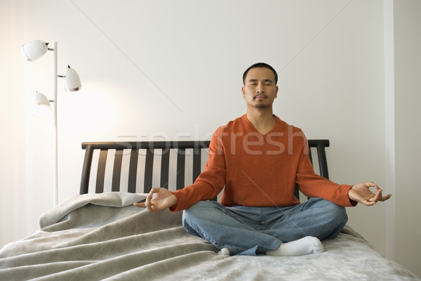 Young Man Meditating In Bedroom Stock Photo C Iofoto 5040