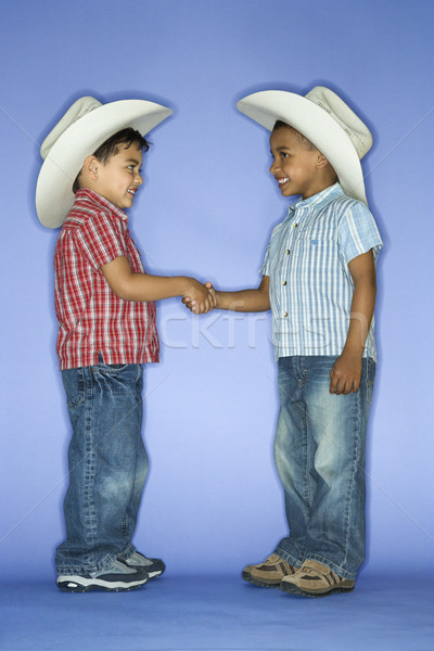 Boys in cowboy hats shaking hands. Stock photo © iofoto