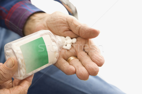 Man pouring pills into hand. Stock photo © iofoto