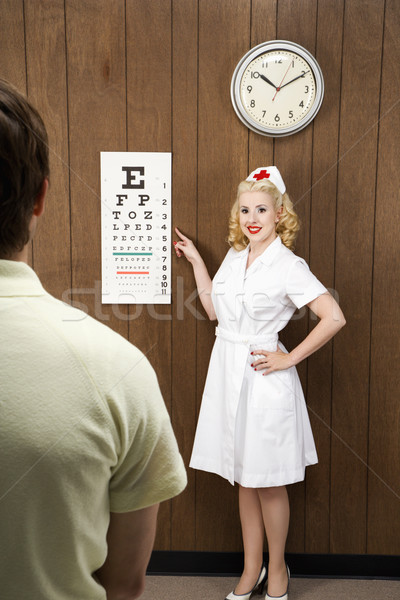 Pielęgniarki pacjenta kobiet wskazując na zewnątrz Zdjęcia stock © iofoto