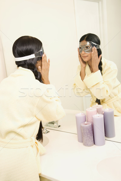 Stock photo: Young woman looking in mirror.