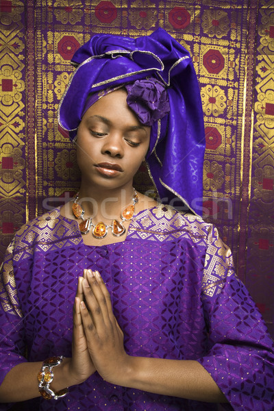 Young African American Woman Praying and Wearing Traditional African Dress Stock photo © iofoto