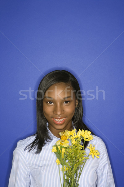 Girl smiling holding flowers. Stock photo © iofoto