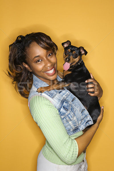 Stock photo: Woman holding small dog.