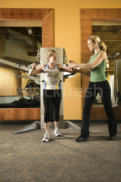 Woman helping woman excercise. Stock photo © iofoto