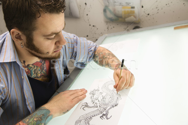 Tatuaj artist caucazian masculin desen lumina Imagine de stoc © iofoto