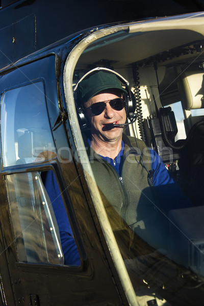 Mężczyzna pilota śmigłowca portret posiedzenia kabina pilota Zdjęcia stock © iofoto