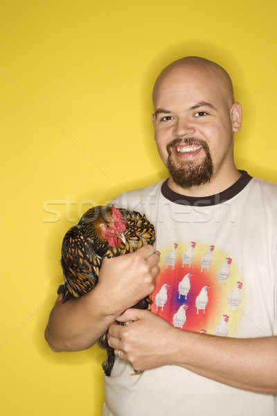 Smiling man holding chicken. Stock photo © iofoto