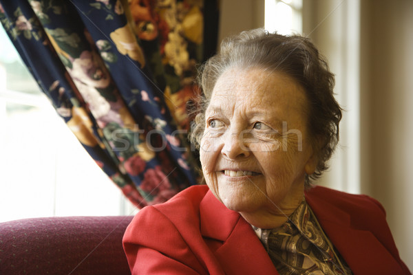 Elderly woman by window. Stock photo © iofoto