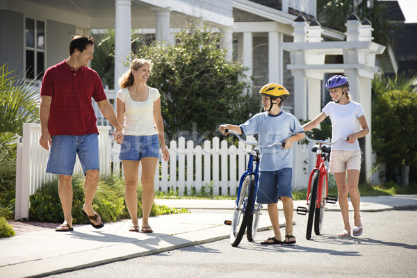 Familie mers biciclete patru împreună trotuar Imagine de stoc © iofoto