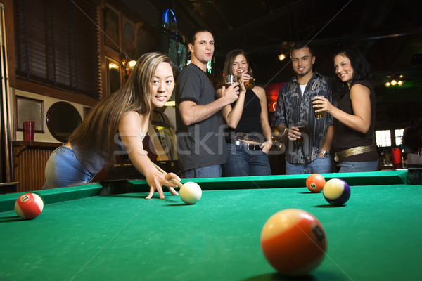 Young female preparing to hit pool ball. Stock photo © iofoto