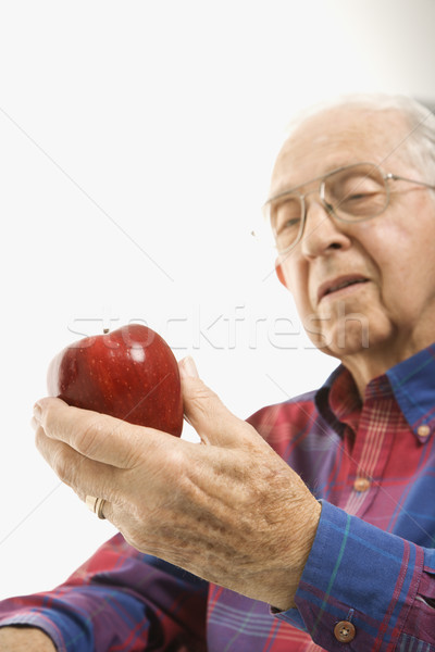 Elderly man holding apple. Stock photo © iofoto