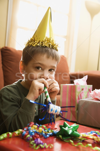 Boy blowing noisemaker. Stock photo © iofoto