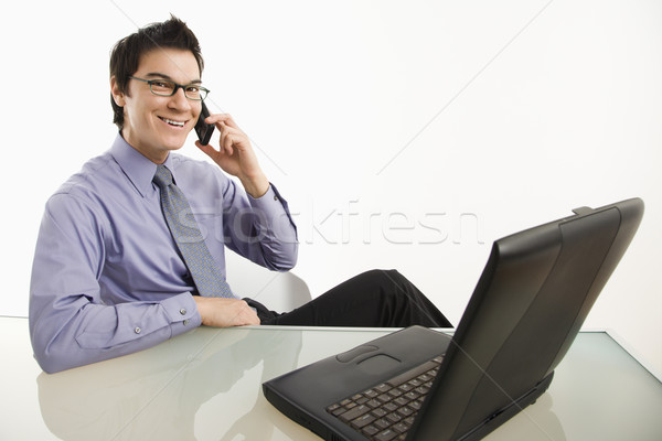Uśmiechnięty biznesmen komórka asian posiedzenia biurko Zdjęcia stock © iofoto