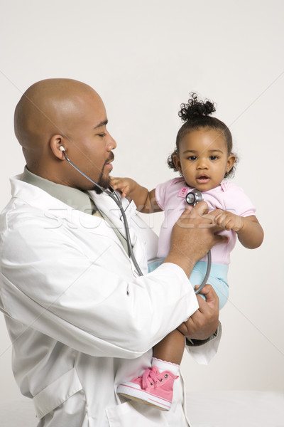 Fată medic masculin pediatru Imagine de stoc © iofoto