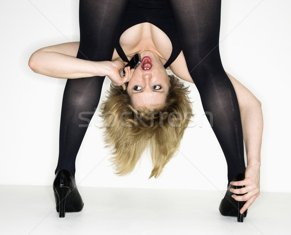 Woman bending while on cellphone. Stock photo © iofoto