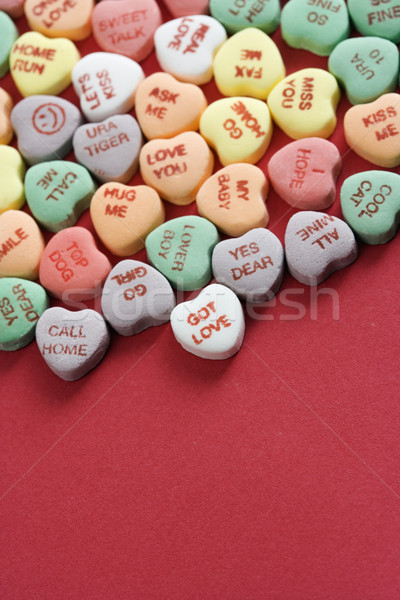 Stock photo: Candy hearts on red.