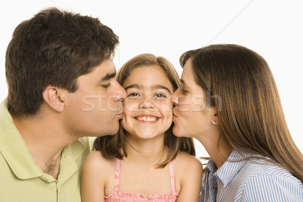 Stock photo: Parents kissing daughter.
