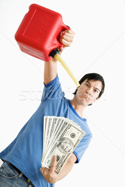 Man pouring gas on money. Stock photo © iofoto