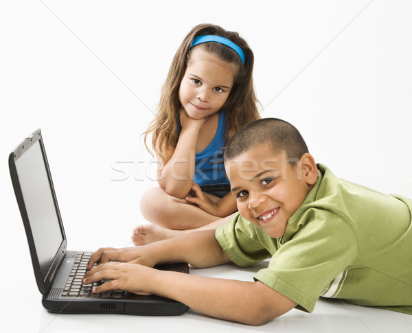 Hispanic boy on laptop with sister. Stock photo © iofoto