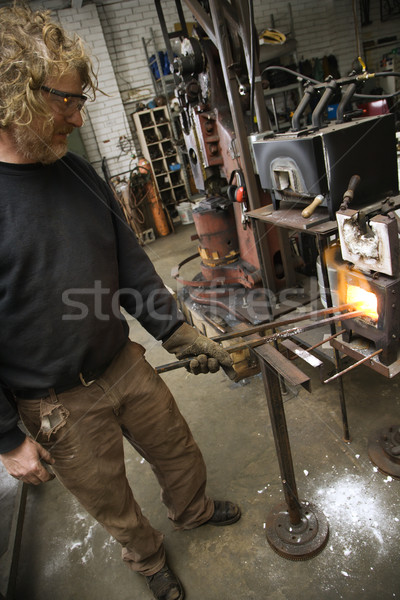 Metalsmith heating metal in forge. Stock photo © iofoto