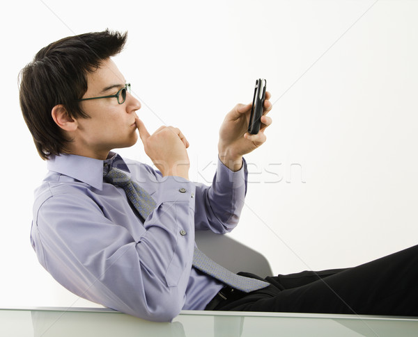 Stock photo: Man looking at cell phone.