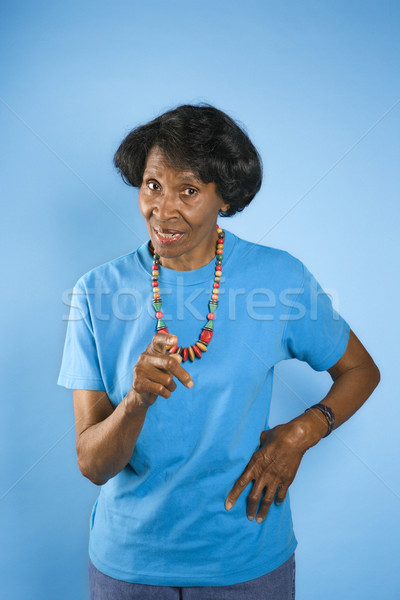 Stock photo: Woman pointing with hand on hip.