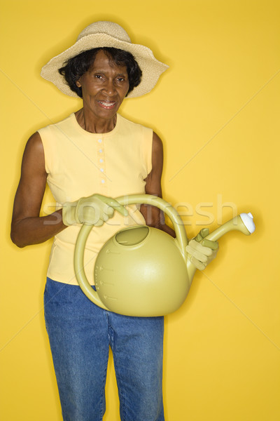 érett nő tart locsolókanna középkorú felnőtt afroamerikai női Stock fotó © iofoto