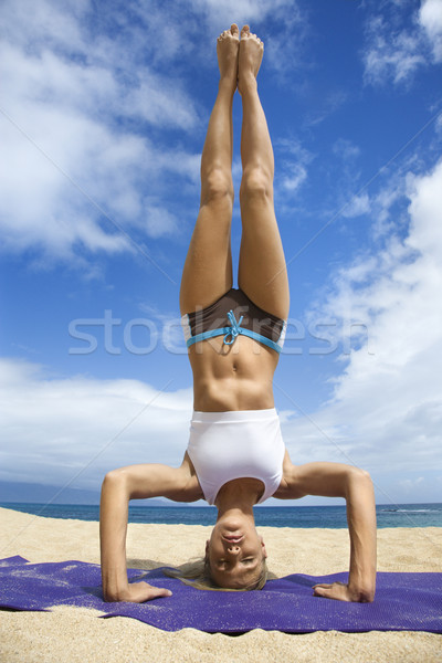 Woman doing yoga on beach. Stock photo © iofoto