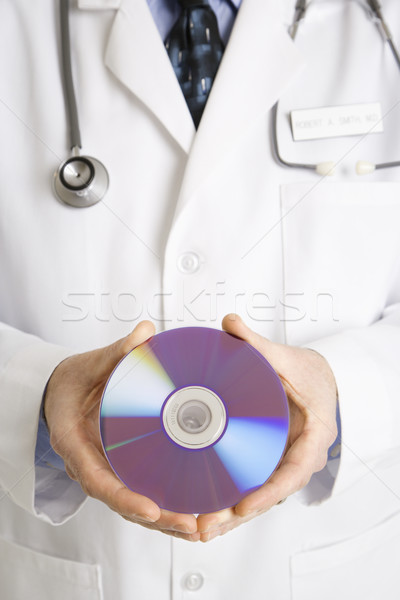 Stock photo: Doctor holding compact disc.